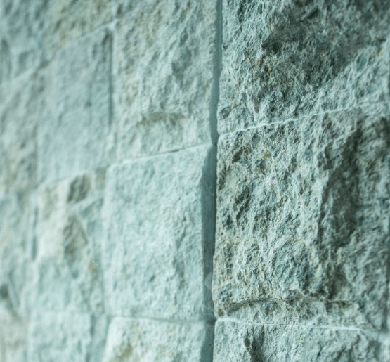 Close-up of rough face Sukabumi Green Stone wall tiles – ideal for water features, pool walls, and tropical architecture